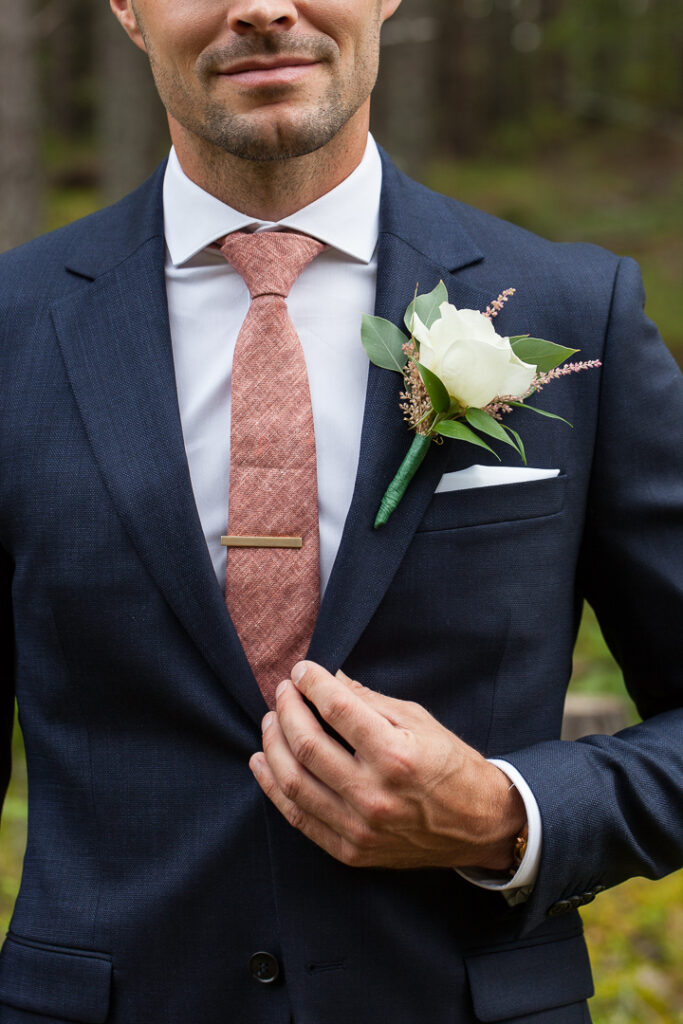 Corsagen den blomma som bärs på kavaj- eller frackslaget av brudgummen vid ett bröllop 