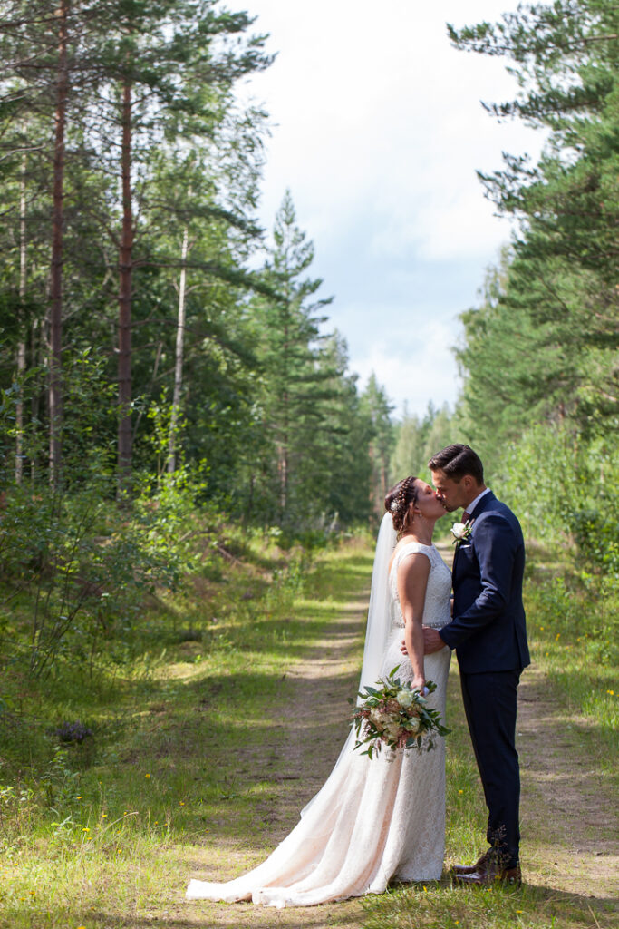 Brudparet i skogen bröllopsfotografering
